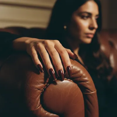 Hand Sharp on a Deep Cognac Leather Couch-arm Showing Long Oxblood Cof